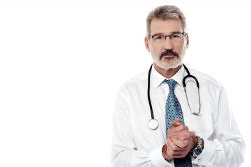 Mature male physician with stethoscope over white